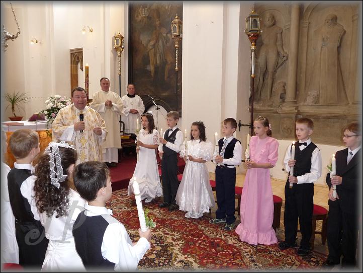 P. Pavel Kopecký mluví k dětem, které mají rozžaty své křestní svíce