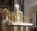  křížek na svatostánku je zahalen bí­lou rouškou, protože svatostánek není­ prázdný