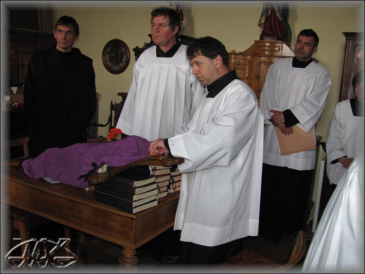 zatímco František zahaluje kříž, zpěváci naslouchají otci Aloisovi