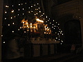 ztemnělý kostel ozařují jen svíčičky na stromcích