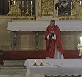 otec Alois káže ze stupňů před oltářem