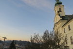 věž kostela ozařují poslední paprsky zapadajícího slunce