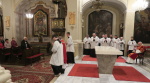 kněz v doprovodu ministrantů odchází pro kříž