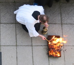 ministrant zapaluje svíci v lucerně od požehnaného ohně