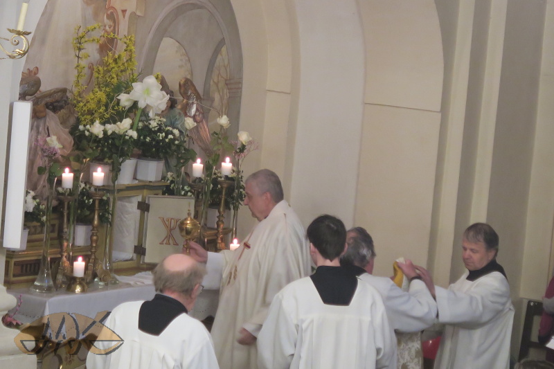 otec Alois vkládá ciborium do svatostánku