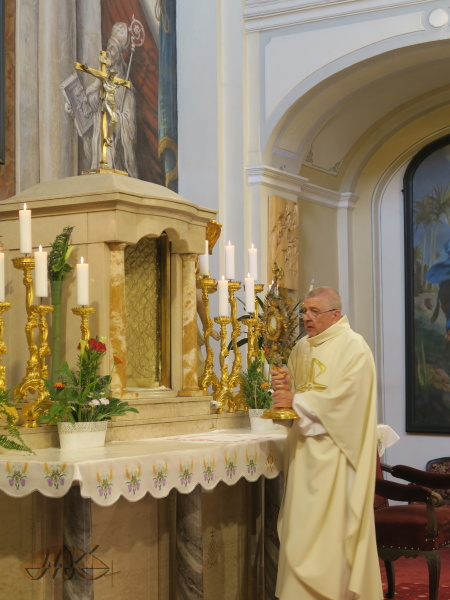 otec Alois přenáší monstranci na obětní stůl